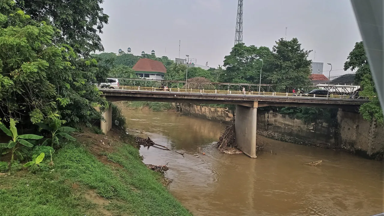 Aliran Kali Bekasi dengan permukaan air kecokelatan di bawah jembatan. (Foto: Kembangraps / Wikimedia Commons, CC BY-SA 4.0)