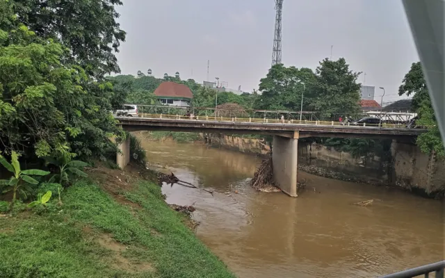 Aliran Kali Bekasi dengan permukaan air kecokelatan di bawah jembatan. (Foto: Kembangraps / Wikimedia Commons, CC BY-SA 4.0)