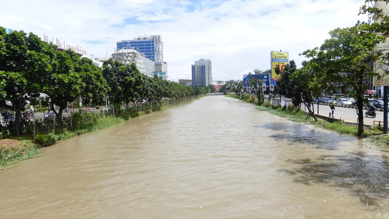 Saluran Kalimalang yang membelah Kota Bekasi, diapit jalan dan pepohonan. (Foto: Jake_T53 / Wikimedia Commons, CC BY-SA 3.0)